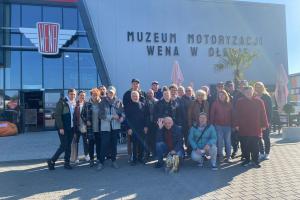 Wycieczkowicze stoją na tle Muzeum Motoryzacji Wena w Oławie