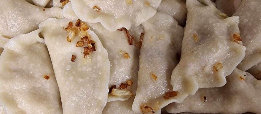 na zdjęciu pokazane są w przybliżeniu pierogi, okraszone przysmażoną cebulką