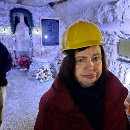 Wyświetl większy obrazek Kaplica świętej Kingi w kopalni soli w Kłodawie. Na pierwszym planie kobieta w kasku ochronnym, na dalszym planie figura Matki Boskiej wyrzeźbiona w soli.