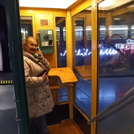 Wyświetl większy obrazek Kobieta pozuje do zdjęcia w budce telefonicznej, przy uchu trzyma słuchawkę